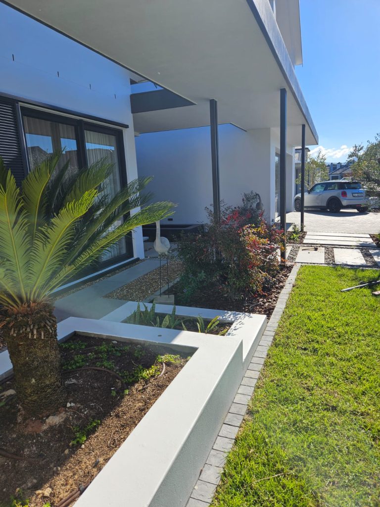 Entrance garden featuring a cycad, flamingo statue and nandina by CSA Landscaping, the best in Boland and Cape Winelands landscaping, at The Acres at Pearl Valley, Paarl
