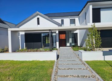 Street view of contemporary home with multi-stem olive trees, clean lawn and modern pathway by CSA Landscaping, the best landscapers in the Boland and Cape Winelands, Val de Vie Estate