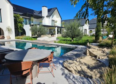 Pool and outdoor living area with olive trees, agapanthus and ornamental grasses at Val de Vie Estate, Paarl, by CSA Landscaping, best landscapers in the Boland and Cape Winelands