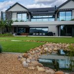 Front garden with Gaura, ornamental grasses and feature trees beside the exposed aggregate driveway at Val de Vie Estate, Paarl, by CSA Landscaping — leading landscapers in the Boland and Cape Winelands
