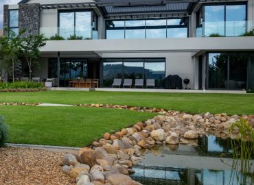 Front garden with Gaura, ornamental grasses and feature trees beside the exposed aggregate driveway at Val de Vie Estate, Paarl, by CSA Landscaping — leading landscapers in the Boland and Cape Winelands