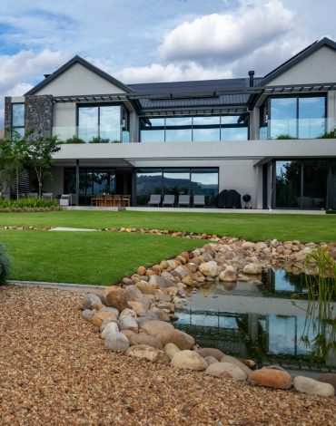 vdm-val-de-vie-dam-lawn-stream-csa-landscaping Front garden with Gaura, ornamental grasses and feature trees beside the exposed aggregate driveway at Val de Vie Estate, Paarl, by CSA Landscaping — leading landscapers in the Boland and Cape Winelands