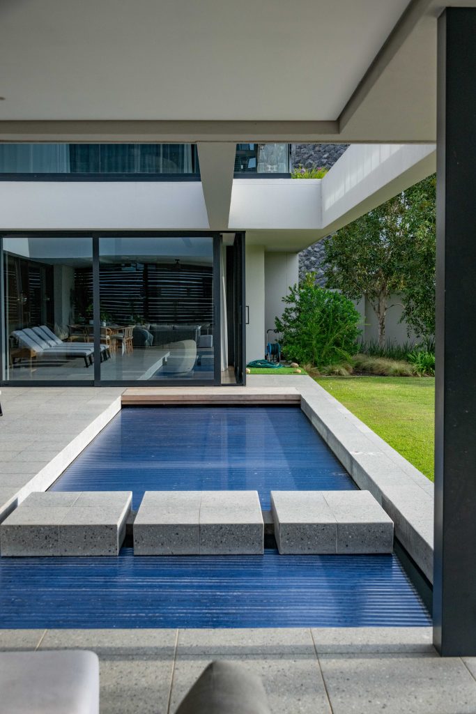 Pool terrace and outdoor dining area opening onto the garden at a contemporary home in Val de Vie Estate, Paarl, by CSA Landscaping — leading landscapers in the Boland and Cape Winelands