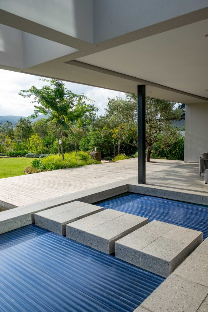 Covered pool terrace with olive trees and layered garden beyond at a contemporary home in Val de Vie Estate, Paarl, by CSA Landscaping — leading landscapers in the Boland and Cape Winelands