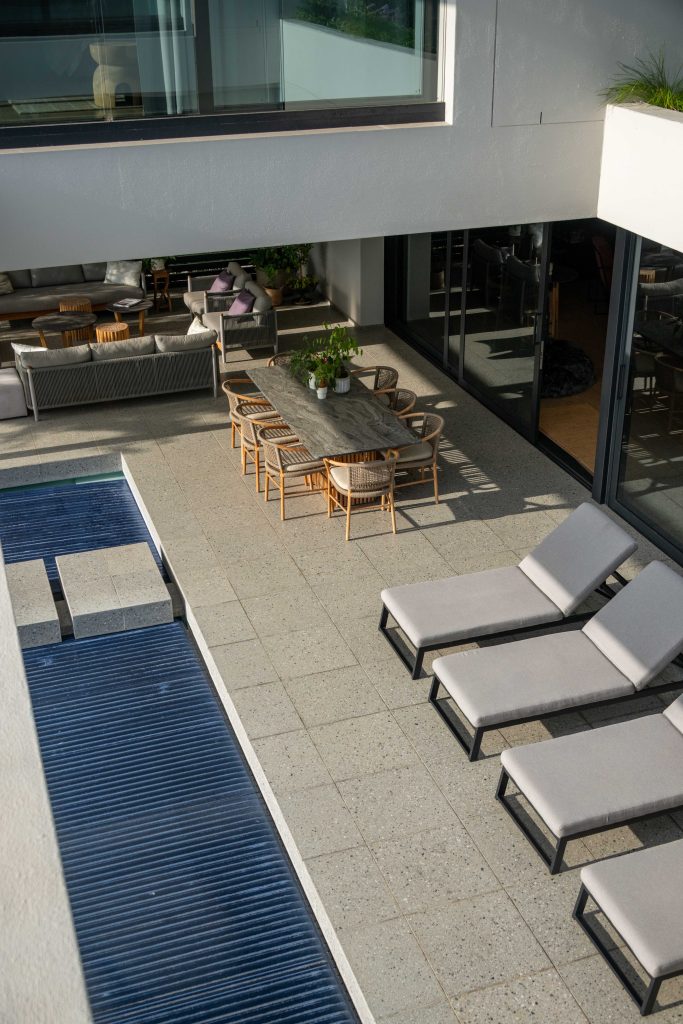 Covered pool terrace with granite stepping blocks, looking through to lawn and planting at Val de Vie Estate, Paarl, by CSA Landscaping — leading landscapers in the Boland and Cape Winelands